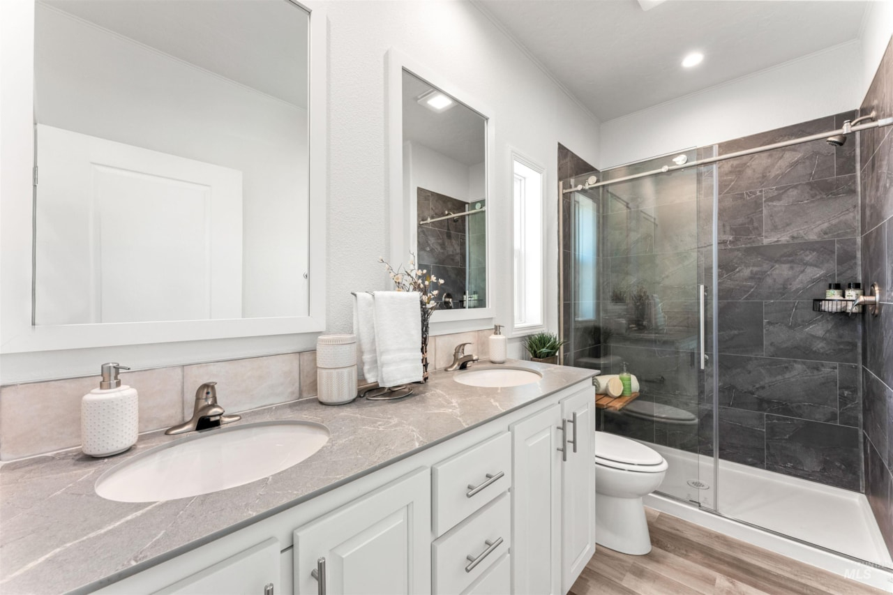 chic bathroom with dual vanity and tiled walk in shower at brooke view in boise id