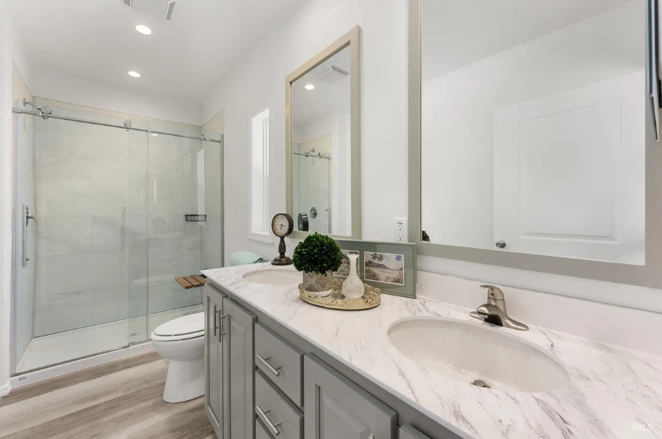 polished bathroom with dual sink vanity and glass shower at brooke view in boise id