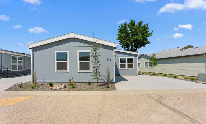 pristine grey manufactured home with paved driveway at brooke view in boise id